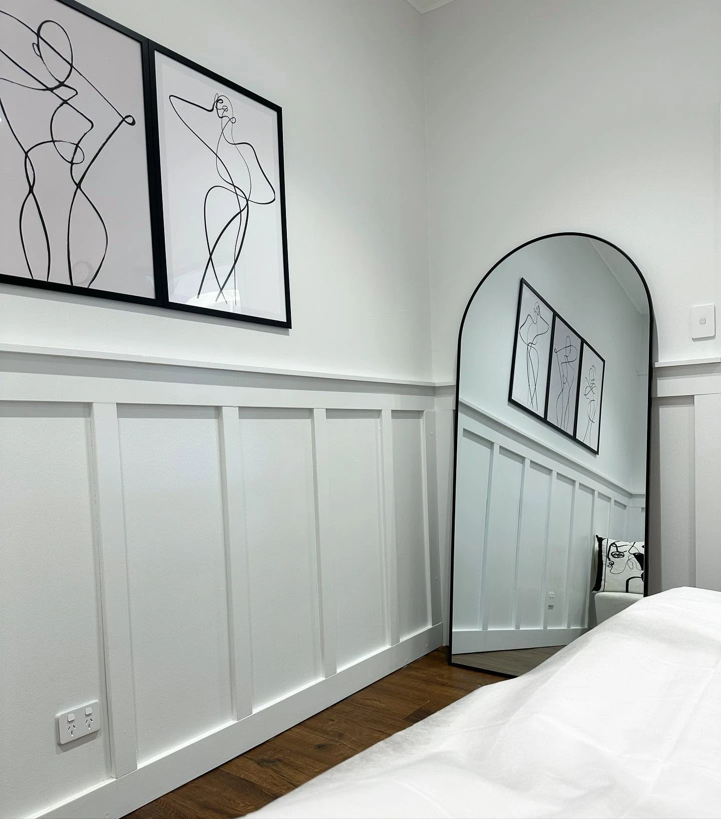Treatment room with line art prints and arched mirror